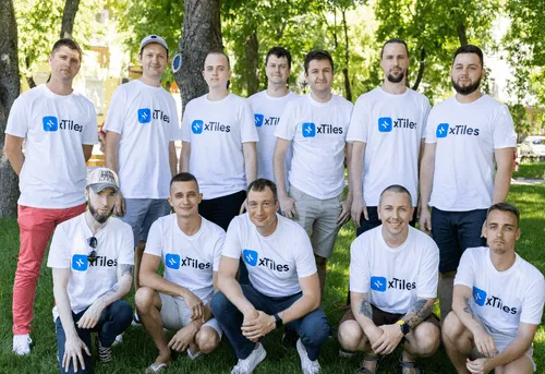The xTiles team posing together outdoors in matching xTiles T-shirts